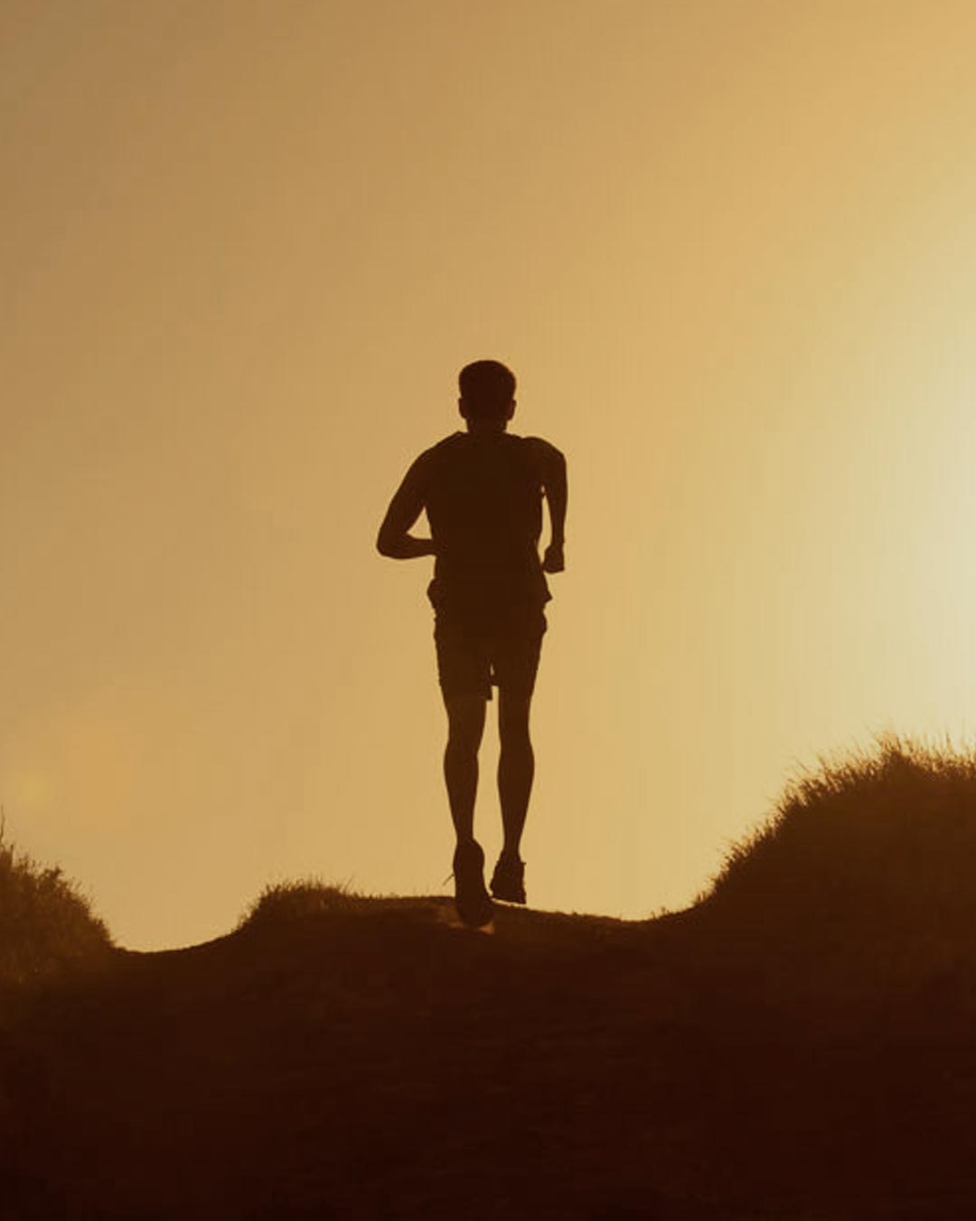 Person stretching at sunset